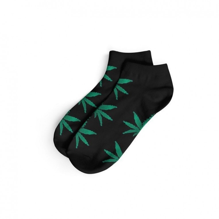 Kurze schwarze Socken und grüne Blätter